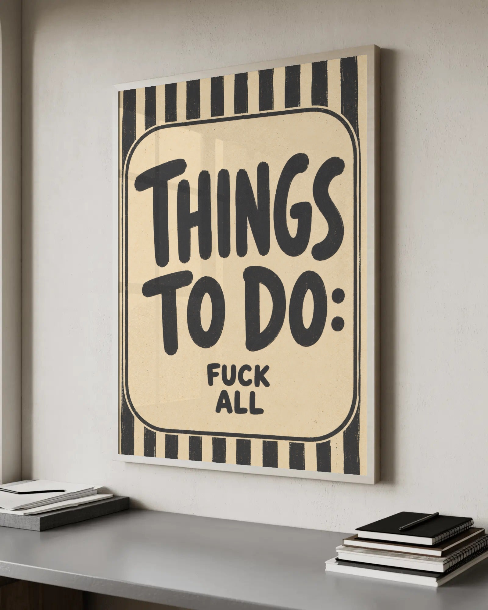 Hand-painted poster lettering reading "Things to do: f*ck all" inside a black-and-cream vertical striped border.